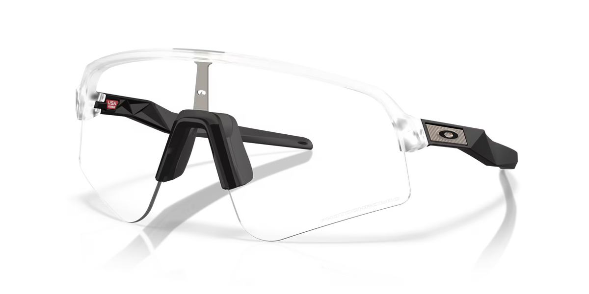 Lunettes de soleil sport Oakley Sutro Lite Sweep Matte Clear Photochromic, vue de face en trois quarts avec monture transparente, branches noires et verres photochromiques.